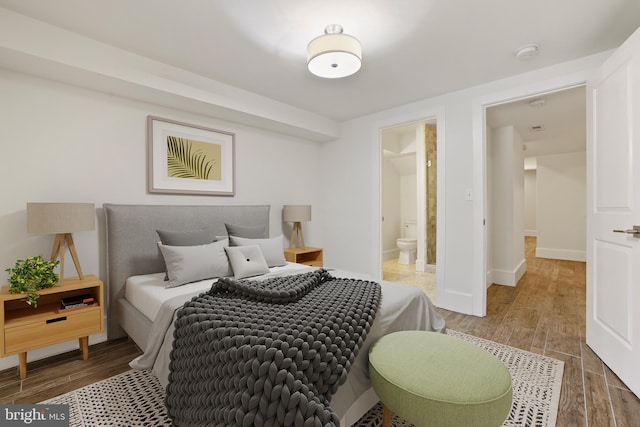 bedroom featuring hardwood / wood-style floors and ensuite bathroom