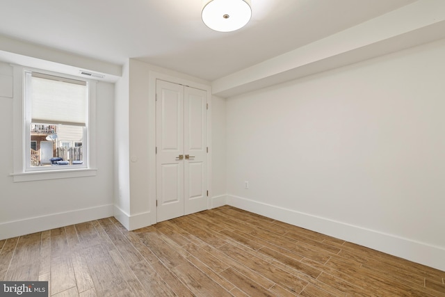 unfurnished bedroom featuring a closet and light hardwood / wood-style flooring