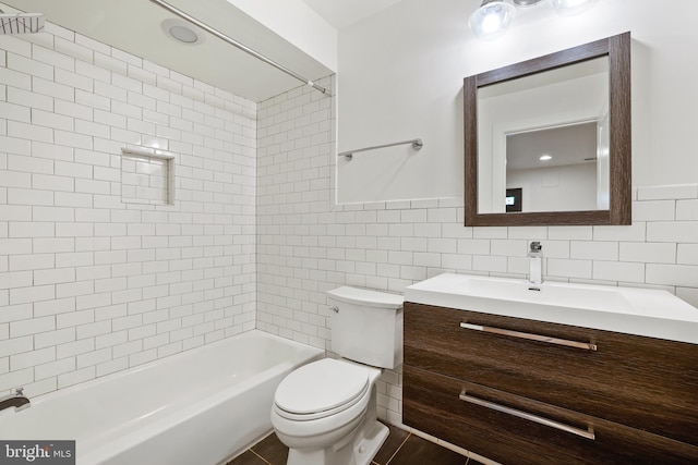 full bathroom with tiled shower / bath, vanity, toilet, and tile walls