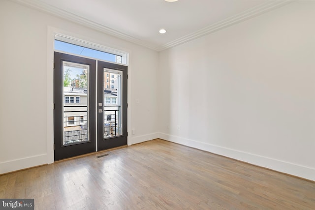 entrance foyer featuring light hardwood / wood-style flooring, crown molding, and french doors