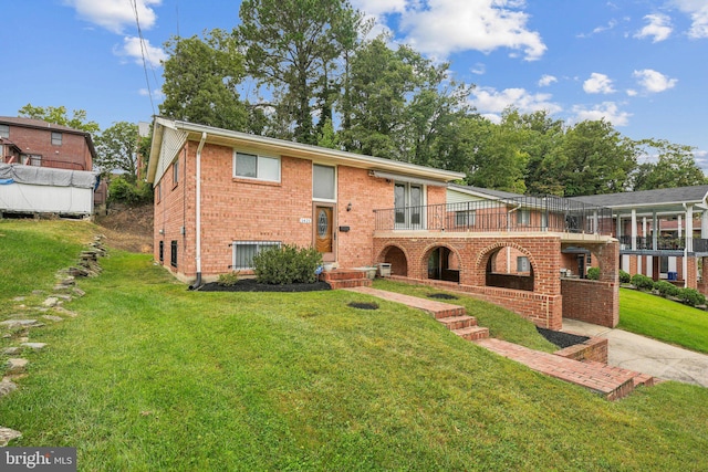 view of front of home featuring a front lawn and central AC