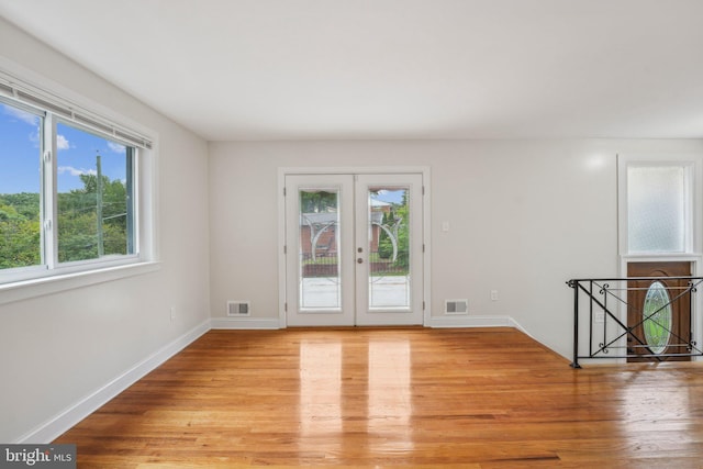 empty room featuring light wood-type flooring and french doors