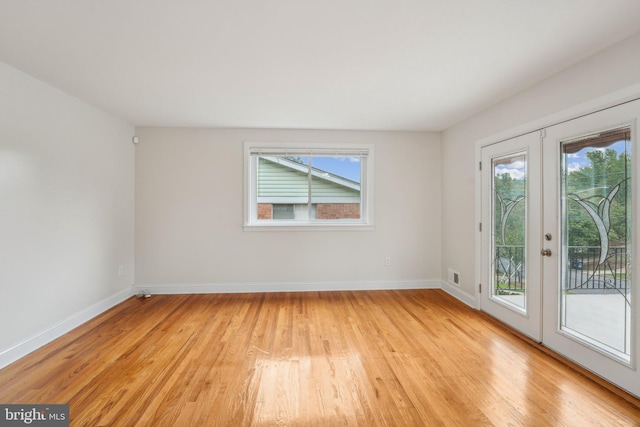 empty room featuring light wood-type flooring and french doors