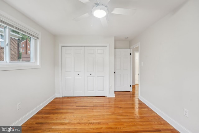 unfurnished bedroom featuring ceiling fan, a closet, and light hardwood / wood-style floors