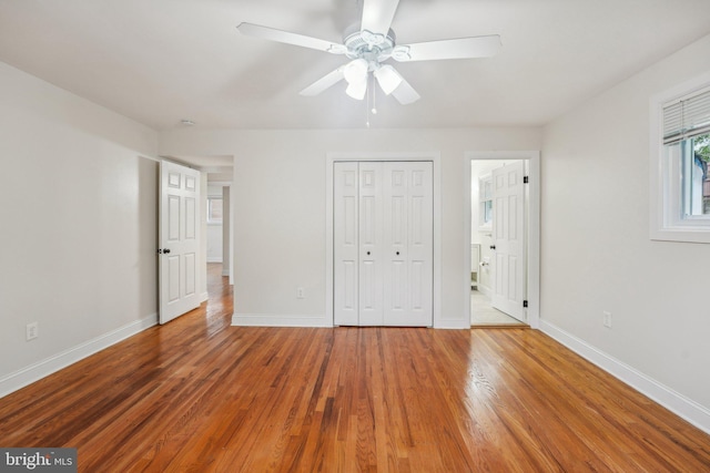 unfurnished bedroom featuring ensuite bathroom, ceiling fan, a closet, and hardwood / wood-style flooring