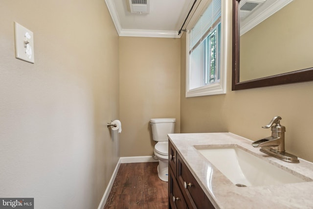 bathroom with hardwood / wood-style flooring, crown molding, vanity, and toilet