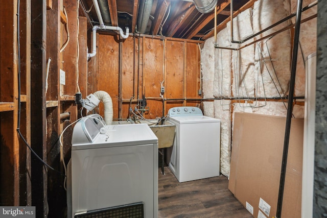 washroom with dark hardwood / wood-style floors, washer and dryer, and sink