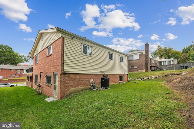 view of side of property with a lawn and central air condition unit