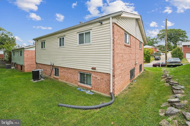 view of property exterior with a yard and central AC unit