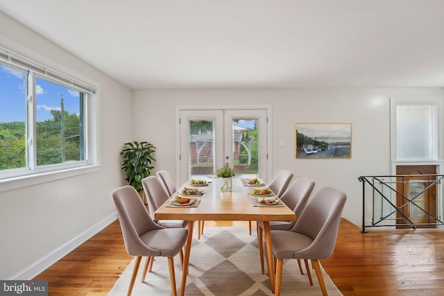 dining space featuring wood-type flooring, french doors, and a wealth of natural light