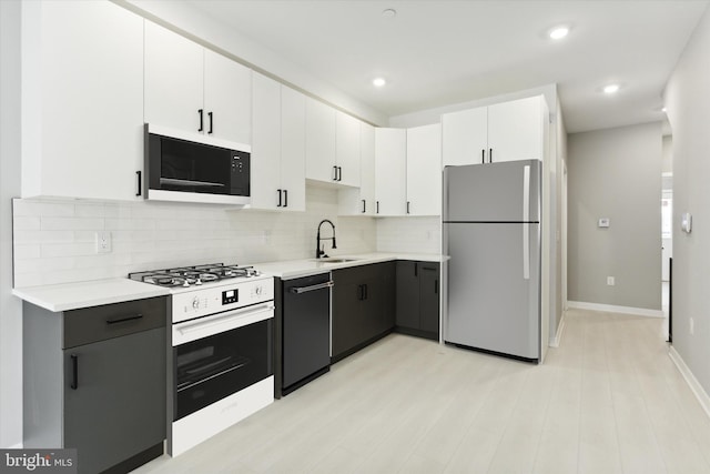 kitchen featuring black appliances, white cabinetry, light hardwood / wood-style flooring, and sink