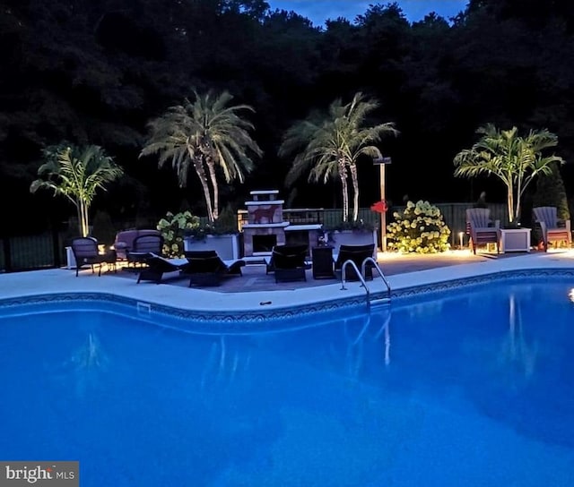 view of pool featuring a patio area and a fireplace