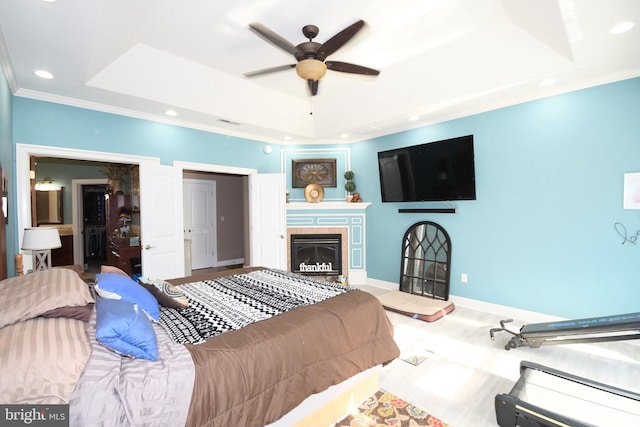 bedroom with a fireplace, a raised ceiling, ceiling fan, and crown molding