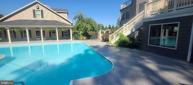 view of swimming pool with ceiling fan and a patio area