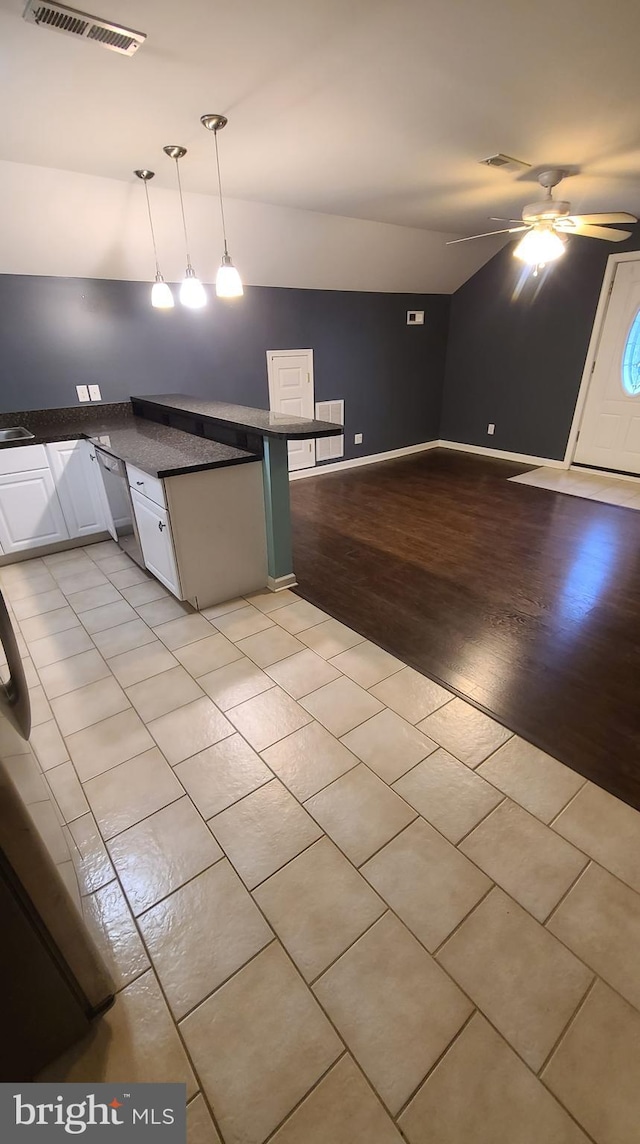 kitchen with lofted ceiling, white cabinets, light hardwood / wood-style flooring, ceiling fan, and decorative light fixtures