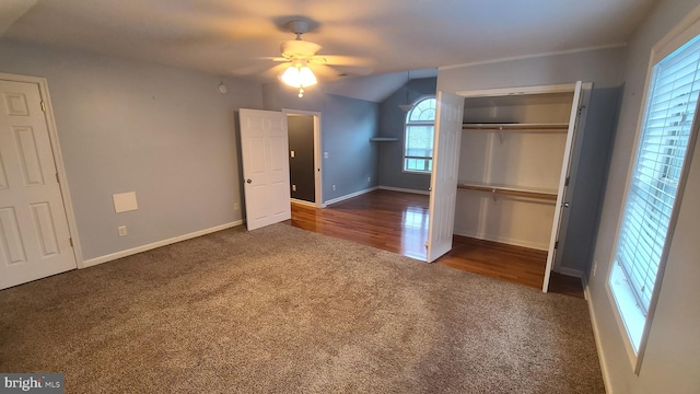 unfurnished bedroom featuring ceiling fan, lofted ceiling, dark wood-type flooring, and a closet