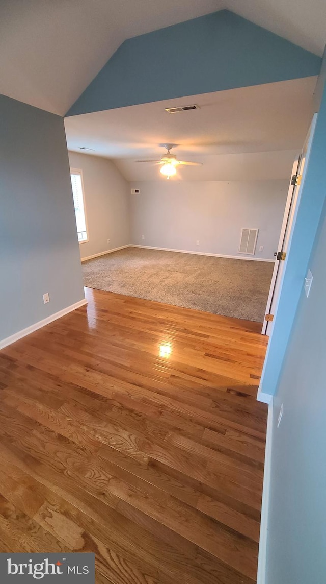 empty room with ceiling fan, wood-type flooring, and lofted ceiling