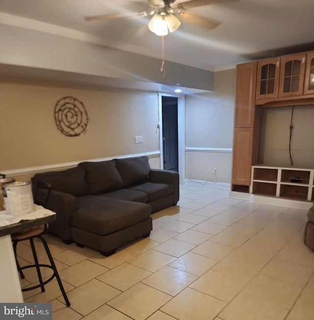 living room featuring ceiling fan, crown molding, and light tile patterned floors