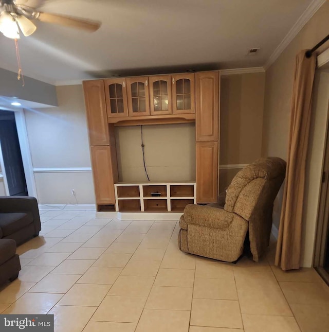 sitting room with ceiling fan, light tile patterned floors, and crown molding