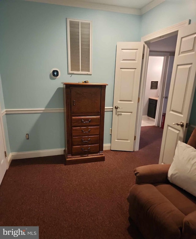 living area with dark carpet and ornamental molding