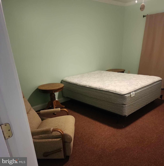 bedroom with dark colored carpet and ornamental molding