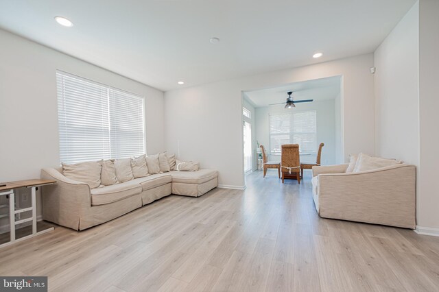 living room with light hardwood / wood-style floors and ceiling fan