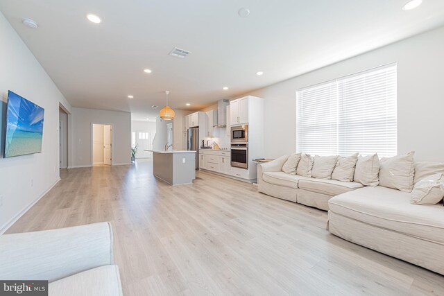 living room with sink and light hardwood / wood-style floors