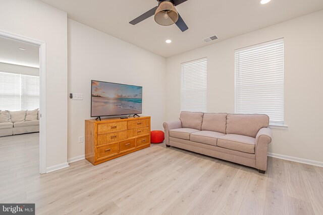 living room featuring light wood-type flooring and ceiling fan