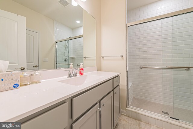 bathroom featuring tile patterned floors, walk in shower, and vanity