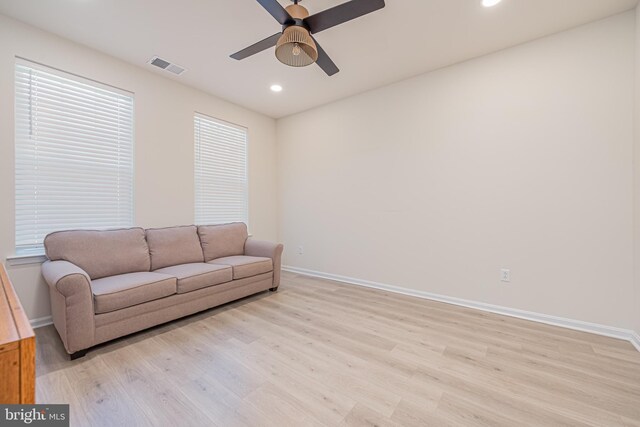 living room with light hardwood / wood-style floors and ceiling fan