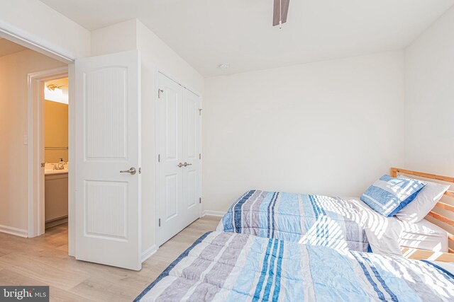 bedroom with ceiling fan, ensuite bathroom, and light hardwood / wood-style floors