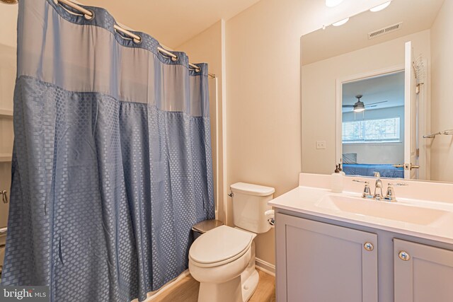 bathroom with ceiling fan, vanity, hardwood / wood-style flooring, a shower with curtain, and toilet