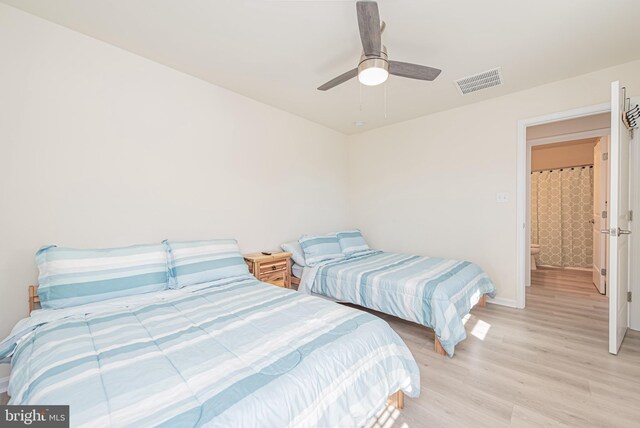 bedroom with ceiling fan, light hardwood / wood-style flooring, and ensuite bath