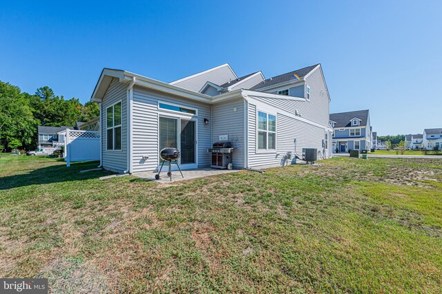 back of house featuring a lawn, a patio area, and central air condition unit