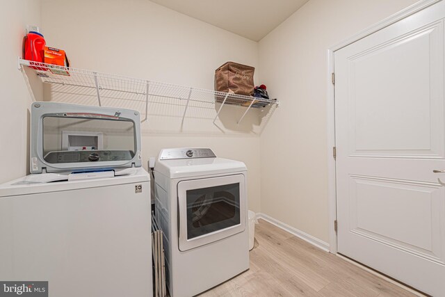 washroom with separate washer and dryer and light wood-type flooring