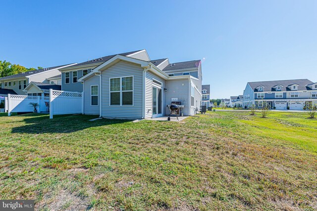 back of property with a lawn and a patio