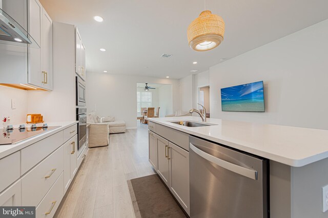 kitchen featuring sink, light hardwood / wood-style flooring, stainless steel appliances, decorative light fixtures, and ceiling fan