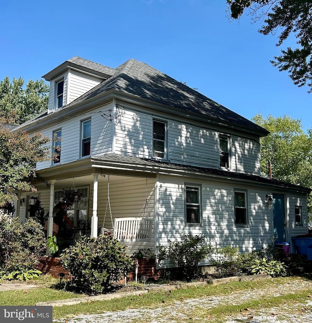 view of side of home with covered porch