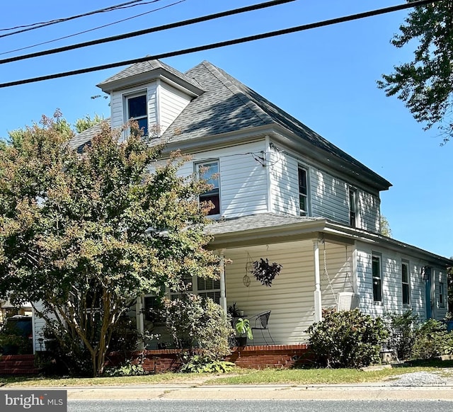 view of side of property featuring roof with shingles