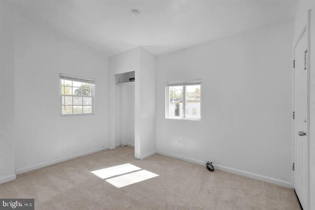 unfurnished bedroom featuring multiple windows and light colored carpet