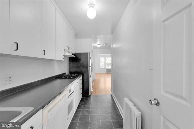 kitchen featuring dark wood-type flooring, white cabinets, radiator heating unit, white dishwasher, and gas stovetop