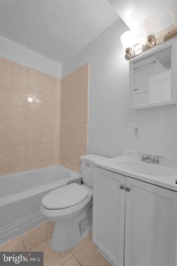 full bathroom featuring tiled shower / bath combo, vanity, toilet, and tile patterned floors