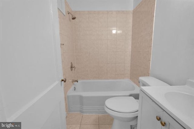 full bathroom with tile patterned flooring, tiled shower / bath combo, vanity, and toilet