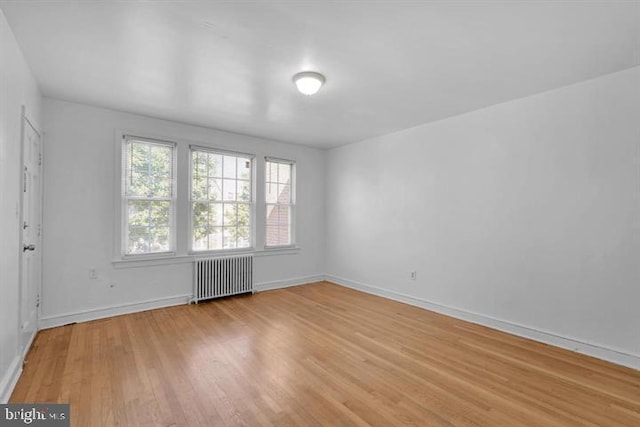 spare room featuring light hardwood / wood-style floors and radiator heating unit