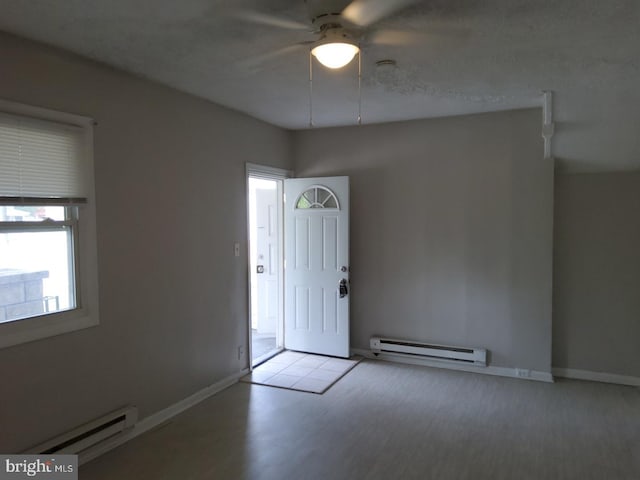 unfurnished room featuring ceiling fan, a baseboard radiator, light hardwood / wood-style floors, and a textured ceiling