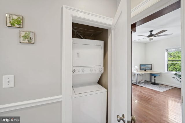 clothes washing area with ceiling fan, stacked washer / drying machine, and hardwood / wood-style flooring