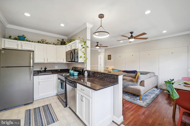 kitchen featuring white cabinets, ceiling fan, appliances with stainless steel finishes, and decorative light fixtures