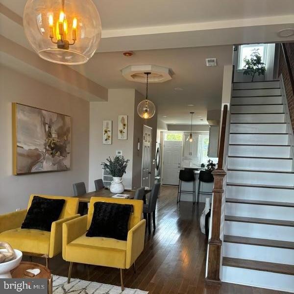 living room featuring a chandelier and dark wood-type flooring