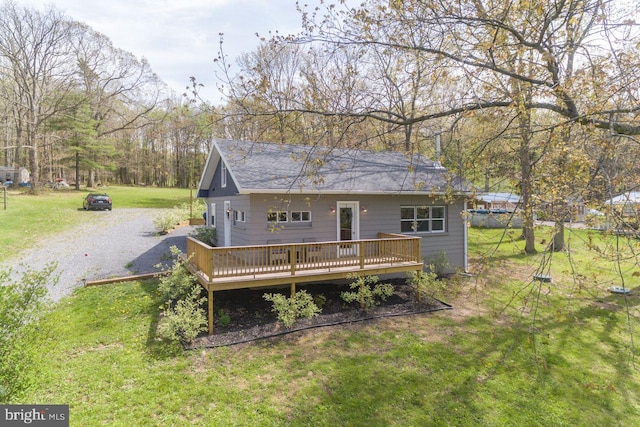 back of property featuring a deck and a yard