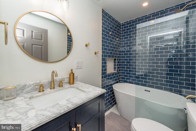 bathroom featuring toilet, vanity, and a bathtub